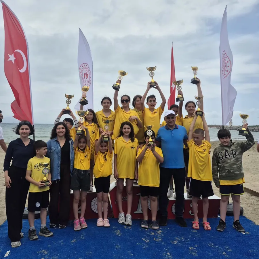Türkiye ve Alanya bayrakları eşliğinde kupalarını kaldıran kulüp yüzücüleri